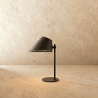 Clérachic table lamp in matte black with an angled cone shade on a slender stem and round base.
