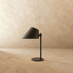 Clérachic table lamp in matte black, close view of the angled cone shade and adjustable joint.