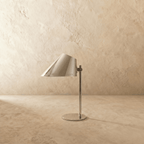 Clérachic table lamp in chrome, close view of the angled cone shade and adjustable metal joint.