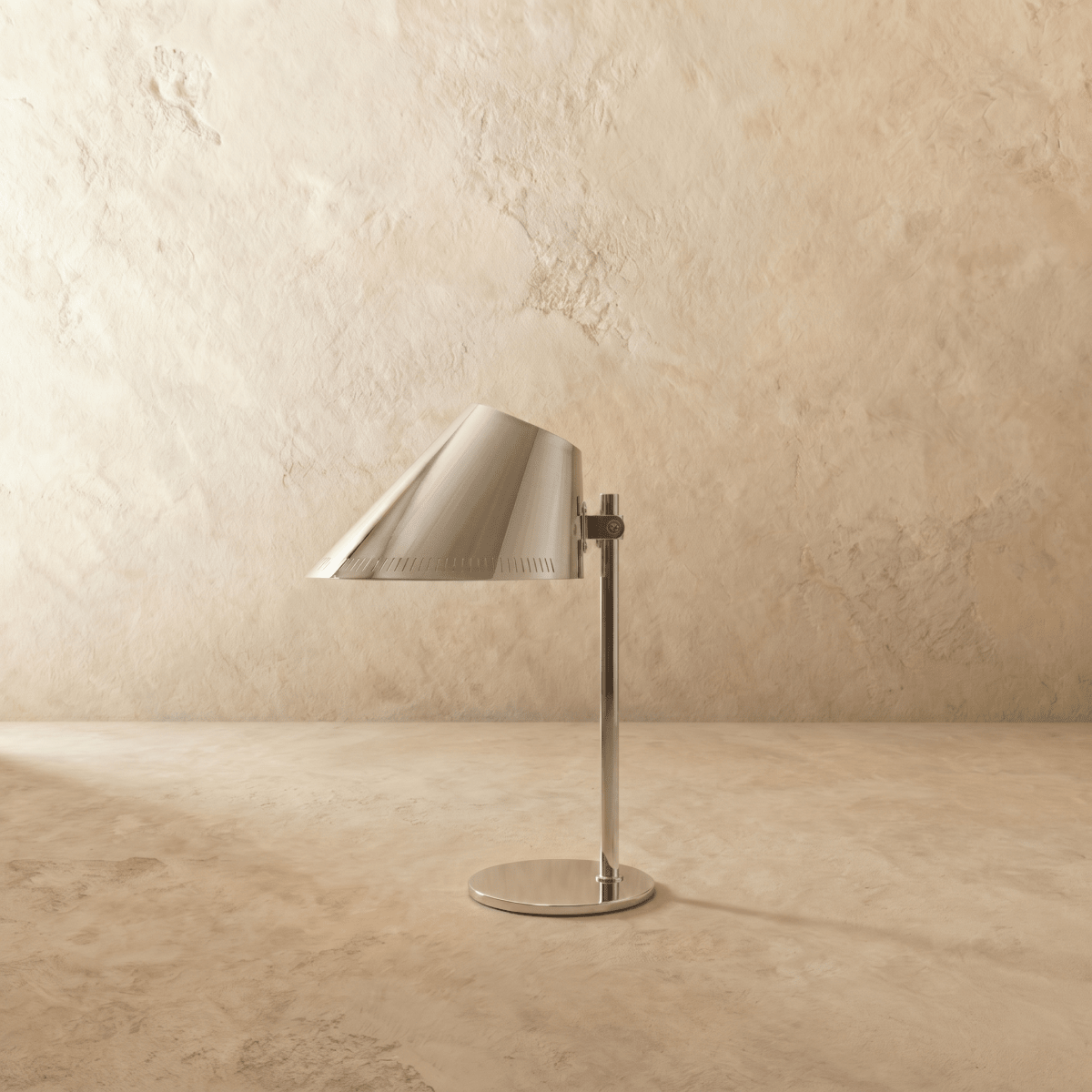 Clérachic table lamp in chrome, close view of the angled cone shade and adjustable metal joint.