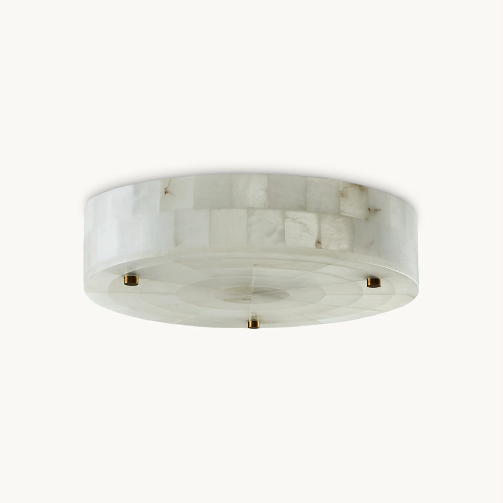 Round flush-mount alabaster ceiling light with a tiled stone rim and brass studs, this Clérachic fitting on a plain white backdrop.