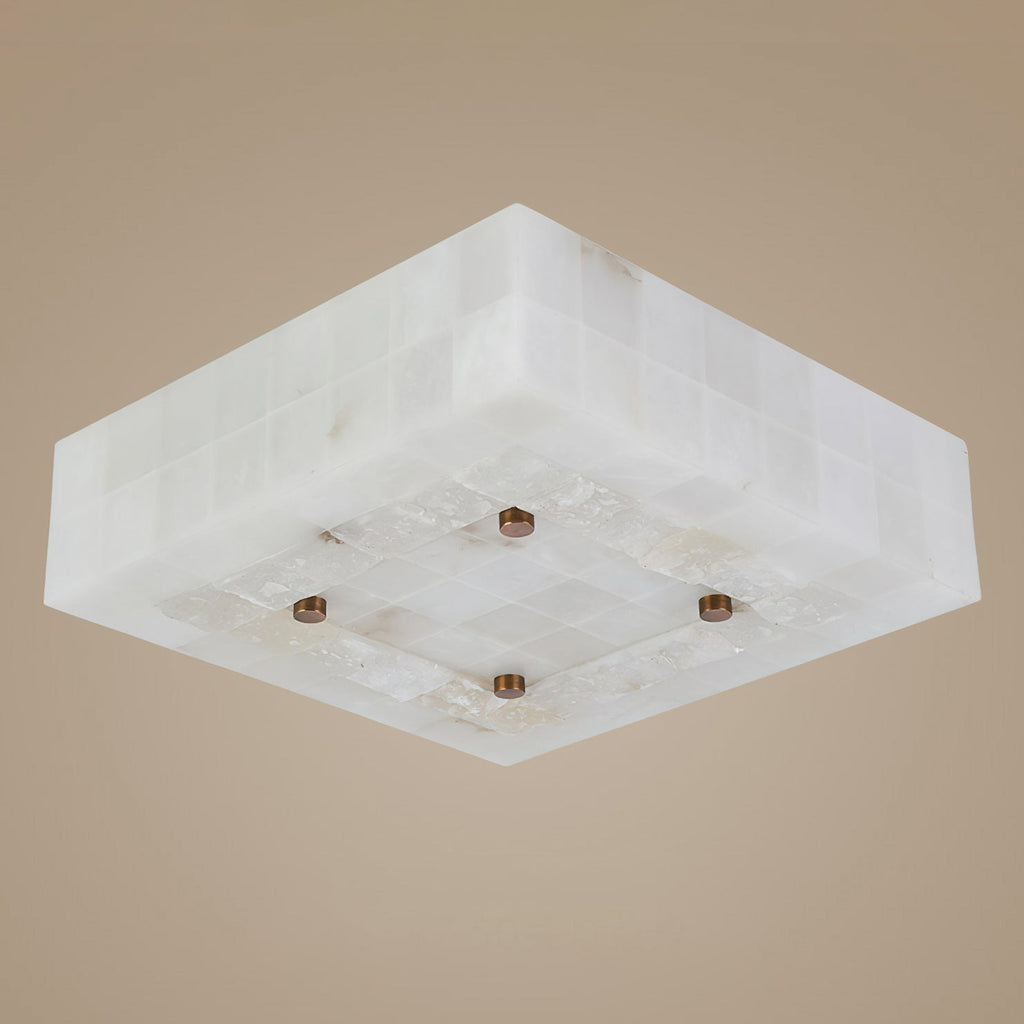 Underside of a square Clérachic alabaster ceiling light, showing the tiled stone sides and four brass studs on a taupe backdrop.