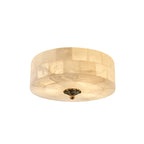 Round Clérachic alabaster ceiling light with a smooth underside and a single brass centre fitting, on a white backdrop.