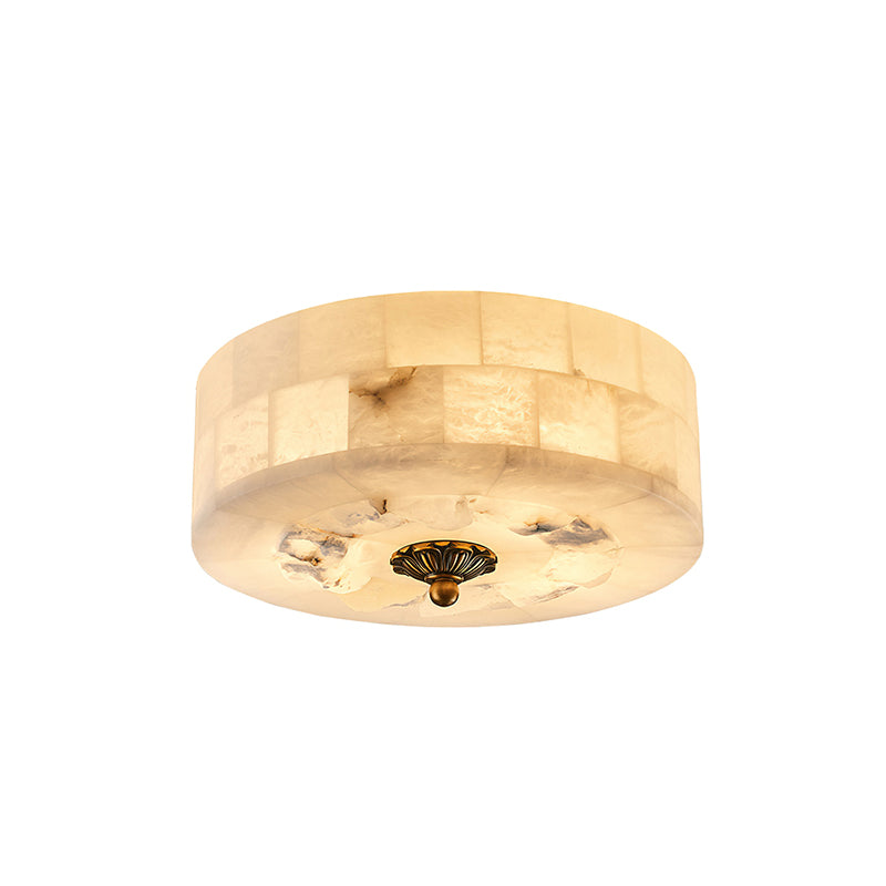 Round Clérachic alabaster ceiling light with a rough stone underside patch and a brass centre cap, seen from slightly below.