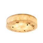 Wide round Clérachic alabaster ceiling light, lit warm, with tiled stone sides and rough stone edging around its underside.