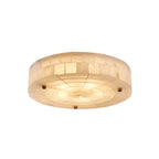 Smooth-bottomed round alabaster ceiling light from Clérachic, glowing with three brass studs and a tiled stone rim, on white.