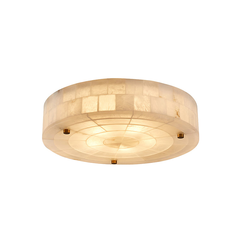 Smooth-bottomed round alabaster ceiling light from Clérachic, glowing with three brass studs and a tiled stone rim, on white.