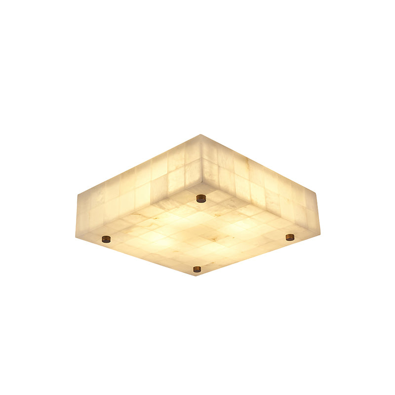 Square Clérachic alabaster ceiling light, lit, with four brass studs at the corners and a tiled underside, on white.