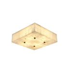 Square alabaster ceiling light from Clérachic, lit, shown at an angle with four brass studs and tiled stone sides on white.