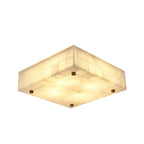 Low square Clérachic alabaster ceiling light with its tiled stone shade glowing and brass studs set near each corner.