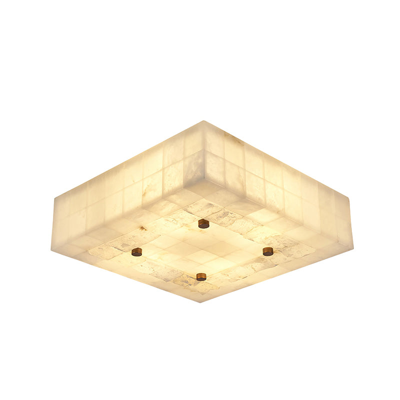 Wide, flat square Clérachic alabaster ceiling light, lit warm, with four brass studs and rough stone patches on the underside.