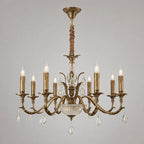 Seen from the front on a plain grey backdrop, a Clérachic antique brass chandelier hangs by a fabric-wrapped rod from a brass ceiling cap.