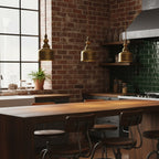 Three antique brass domes from Clérachic hang in a row above a timber counter, in front of a red brick wall and green tiles.
