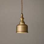 Side view of the brushed brass bell shade and slotted collar of this Clérachic pendant, hanging unlit on its cord.
