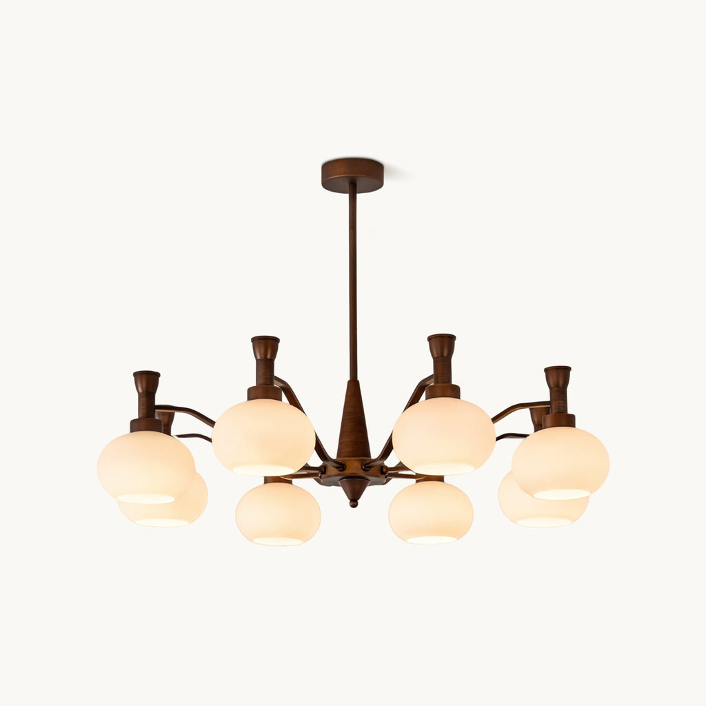 A Clérachic chandelier in antique bronze with cream glass shades on curved arms, shown on a plain white backdrop.