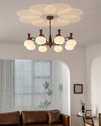 This Clérachic chandelier hangs in a room with an arched alcove, a leafy plant by the window and a brown leather sofa below.