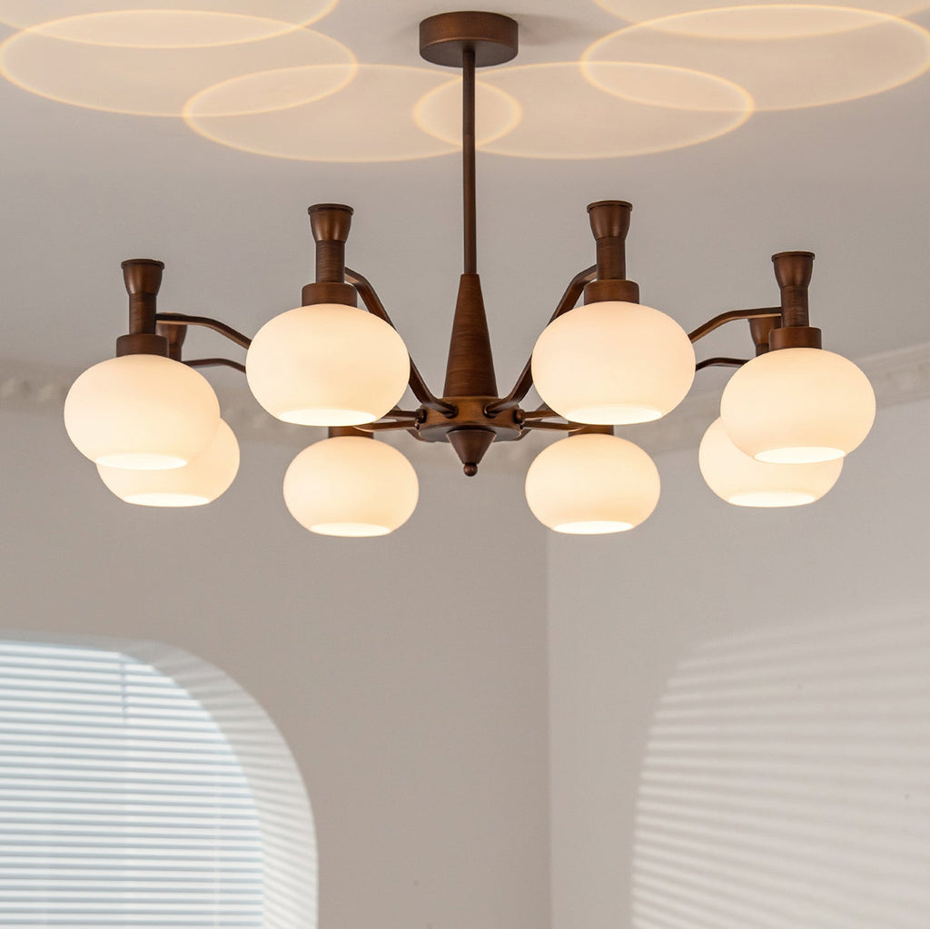 From below, the cream glass globes of this Clérachic chandelier glow under a ceiling patterned with overlapping circles of light.