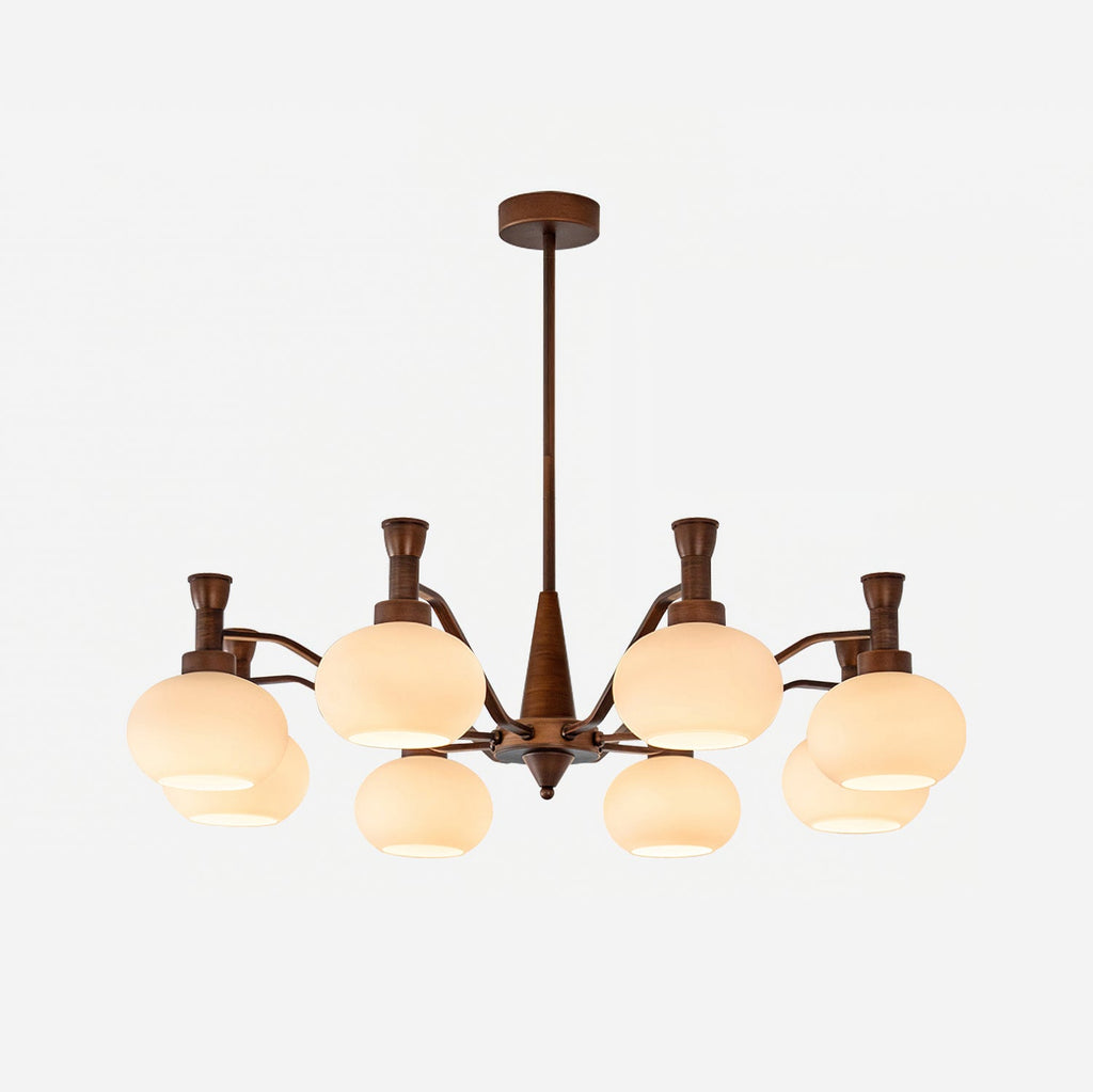 The trumpet-topped arm version of this Clérachic chandelier, unlit, with cream glass shades and a bronze stem on a white backdrop.