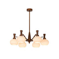 Smaller trumpet-arm Clérachic chandelier with cream glass globes and a long bronze rod, on a plain white backdrop.