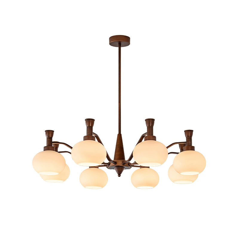 Mid-size Clérachic chandelier in antique bronze with trumpet-topped arms and cream glass globes, on a plain white backdrop.