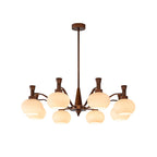 Mid-size Clérachic chandelier in antique bronze with trumpet-topped arms and cream glass globes, on a plain white backdrop.