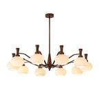 The widest trumpet-arm Clérachic chandelier, with antique bronze arms spreading out around cream glass globes, on a white backdrop.