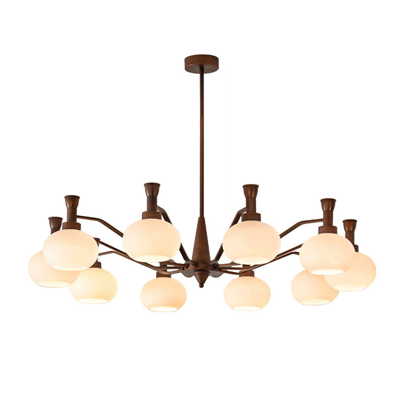 The widest trumpet-arm Clérachic chandelier, with antique bronze arms spreading out around cream glass globes, on a white backdrop.