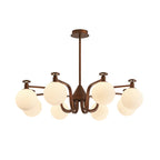 Round cream globes on a swept-arm antique bronze frame, this Clérachic chandelier hangs from a rod and flat ceiling plate on white.
