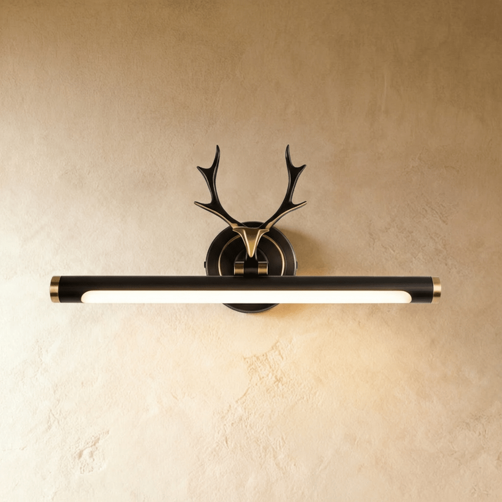 Clérachic antler wall light in dark bronze black with gold end caps and a lit 43 cm tube, on a warm limewash wall.