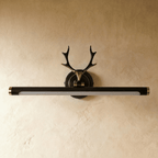 Clérachic black and gold antler wall light with its 55 cm tube unlit, a frosted diffuser along the underside, on plaster.