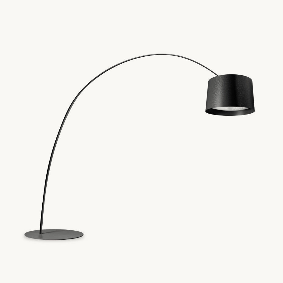 Black Clérachic arc floor lamp with a long curved arm, a drum shade and a round flat base, on a plain white background.
