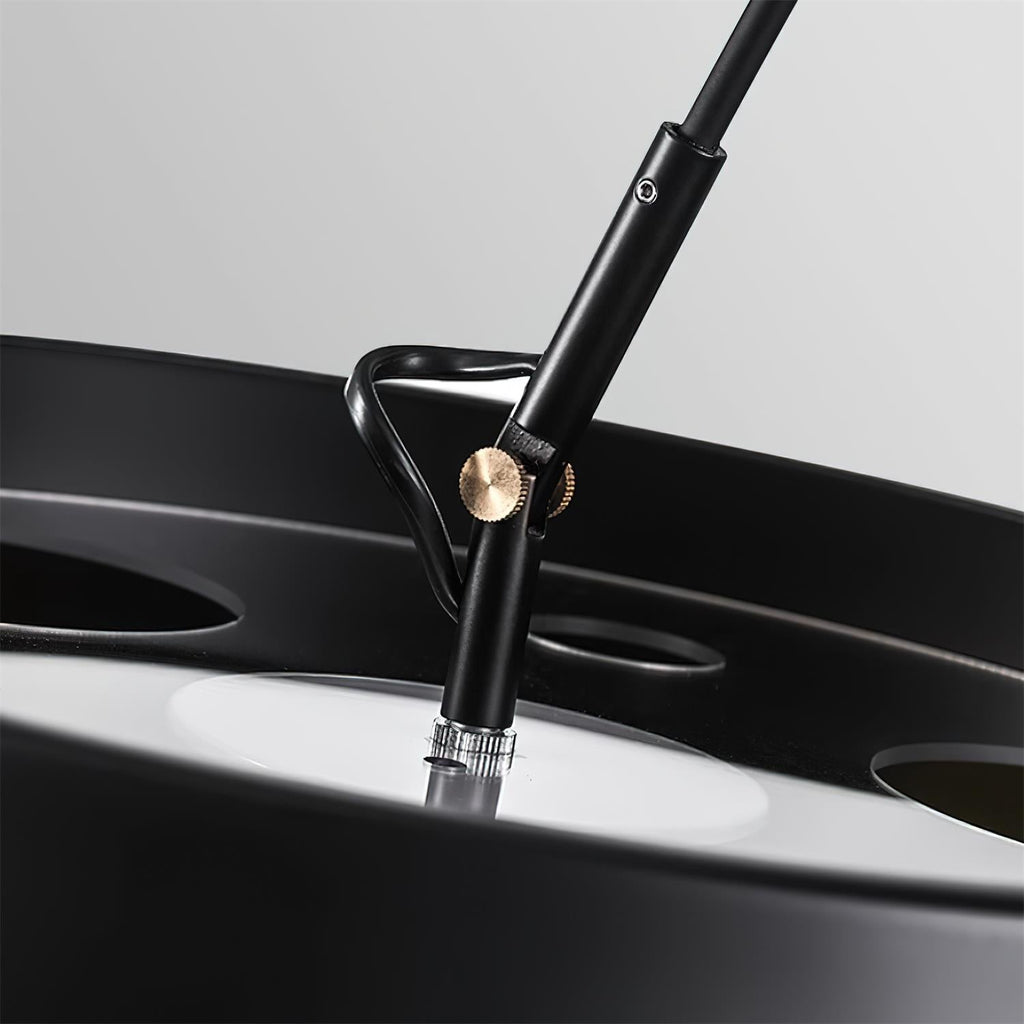 Close view of the joint where the arm meets the shade on this Clérachic arc floor lamp, with a small gold-toned knob.
