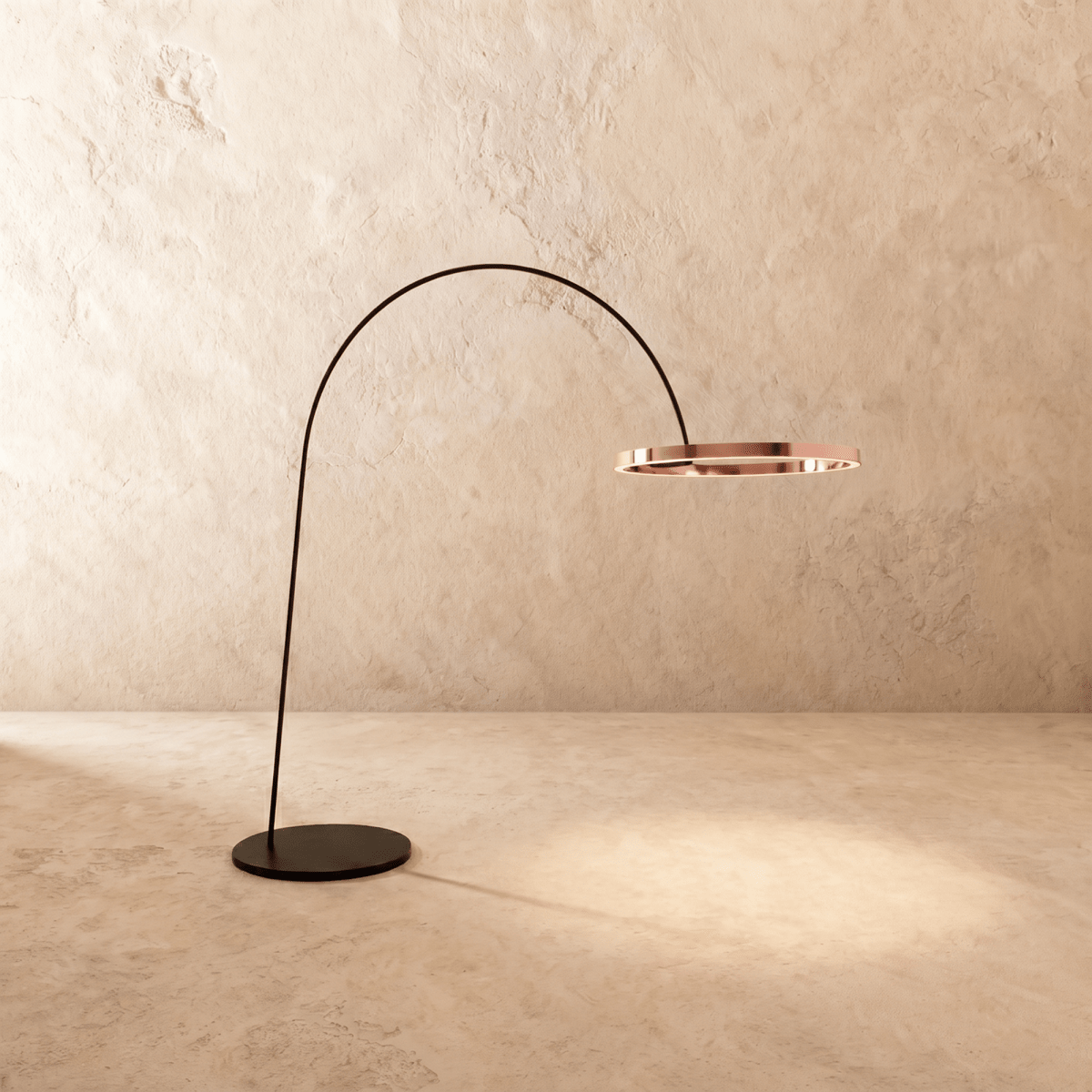 Clérachic arc floor lamp with a polished rose gold ring on a black arm, casting a soft pool of light on the floor.