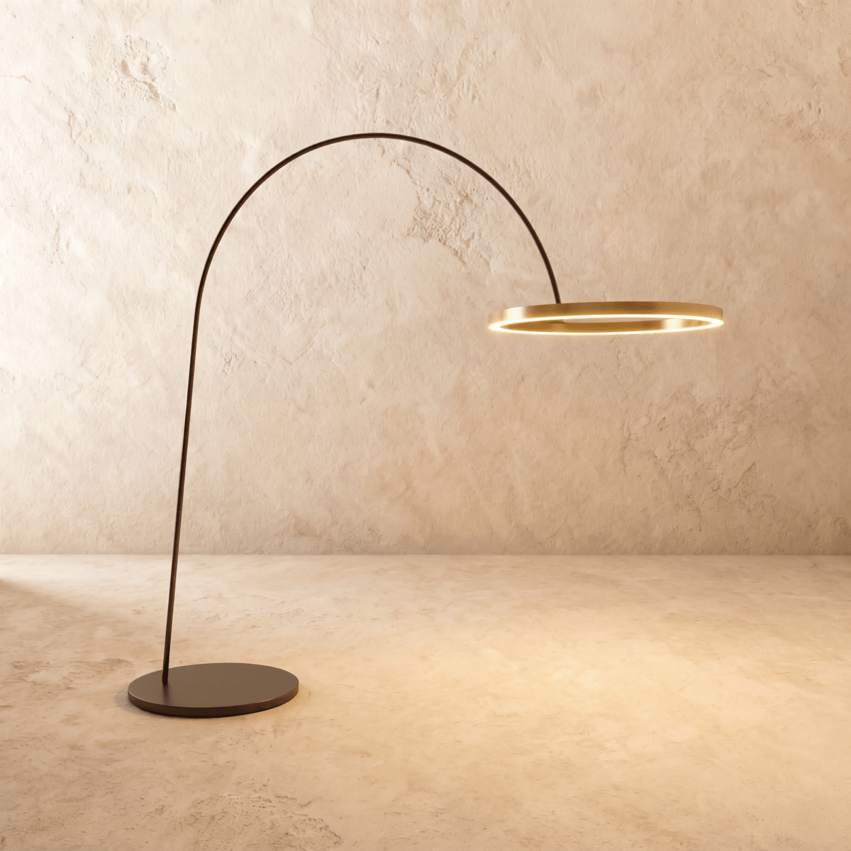 Clérachic taller arc floor lamp with a brushed gold ring and wider black base, glowing warm against a limewash wall.