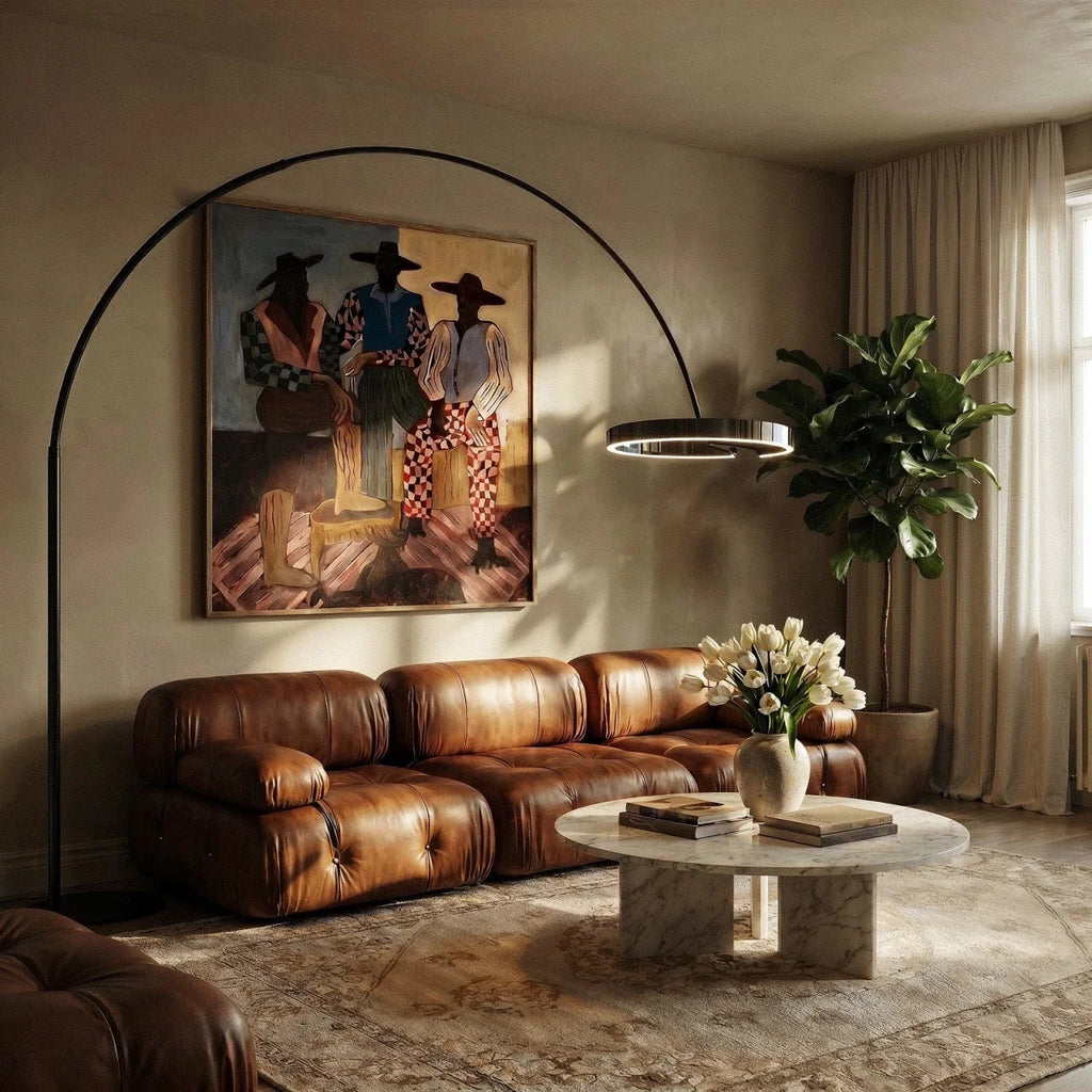 Clérachic arc floor lamp with a black ring arching over a tan leather sofa and marble coffee table in a living room.