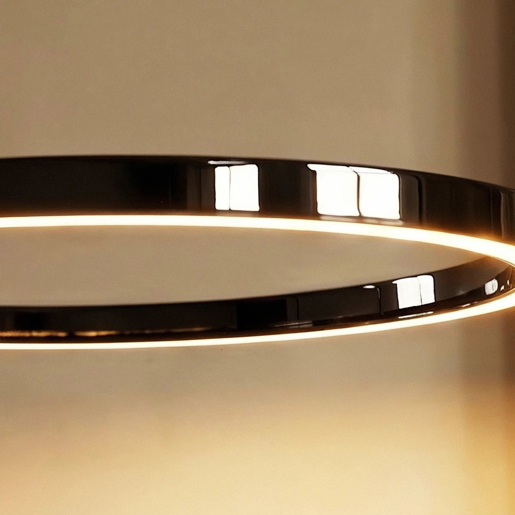 Close view of the Clérachic black ring light, its glossy rim reflecting the room with a warm line of light on the inner edge.