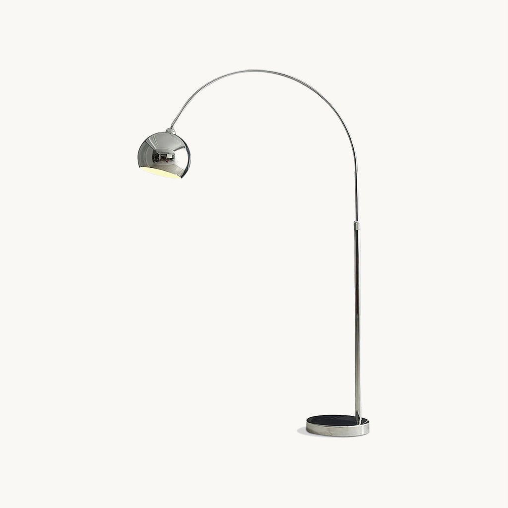Chrome arc floor lamp from Clérachic with a round domed head on a slim stem and a dark disc base, on a plain white backdrop.