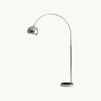 Chrome arc floor lamp from Clérachic with a round domed head on a slim stem and a dark disc base, on a plain white backdrop.