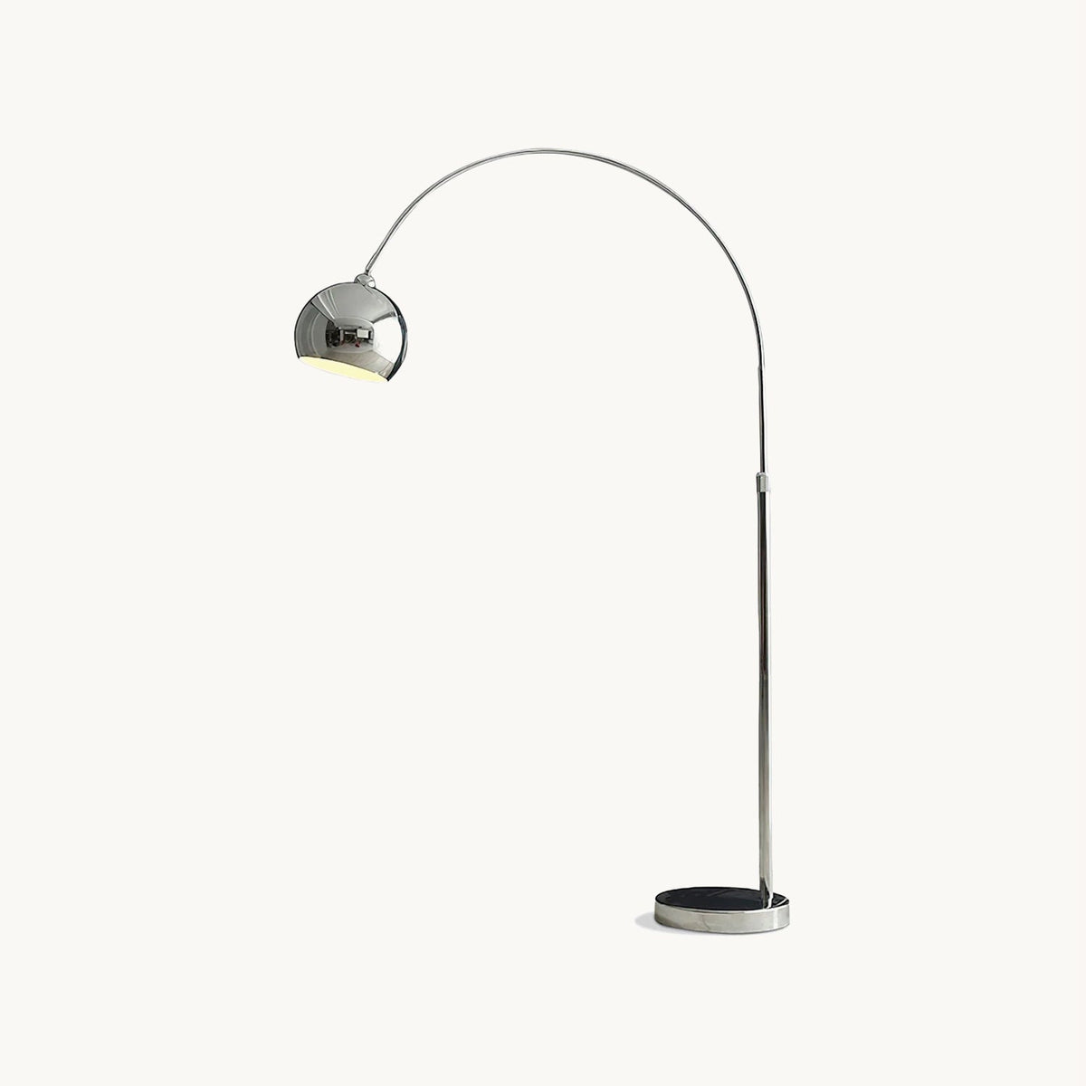 Chrome arc floor lamp from Clérachic with a round domed head on a slim stem and a dark disc base, on a plain white backdrop.