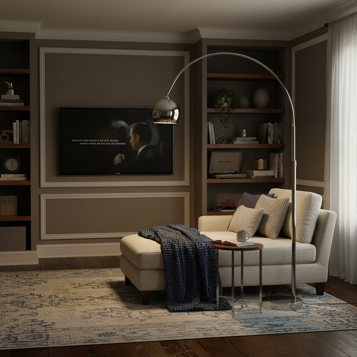 This Clérachic arc lamp leans over a cream chaise with a dark throw, in a den with a wall-mounted screen and built-in shelves.