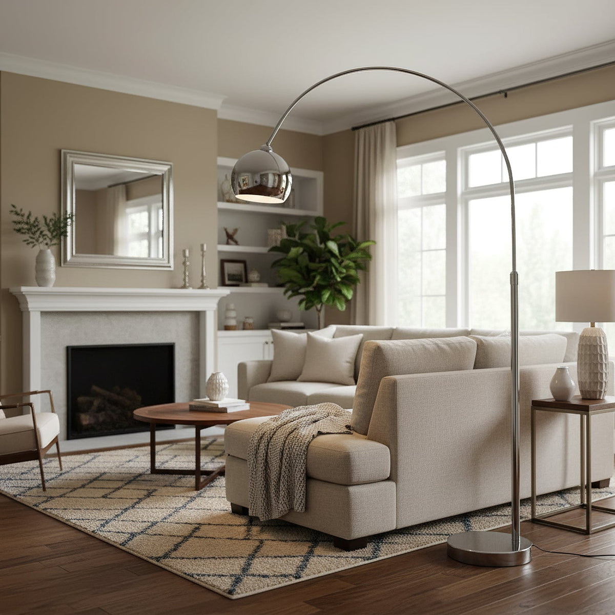 In a living room with a white fireplace and tall windows, a Clérachic chrome arc lamp reaches across a cream sofa.