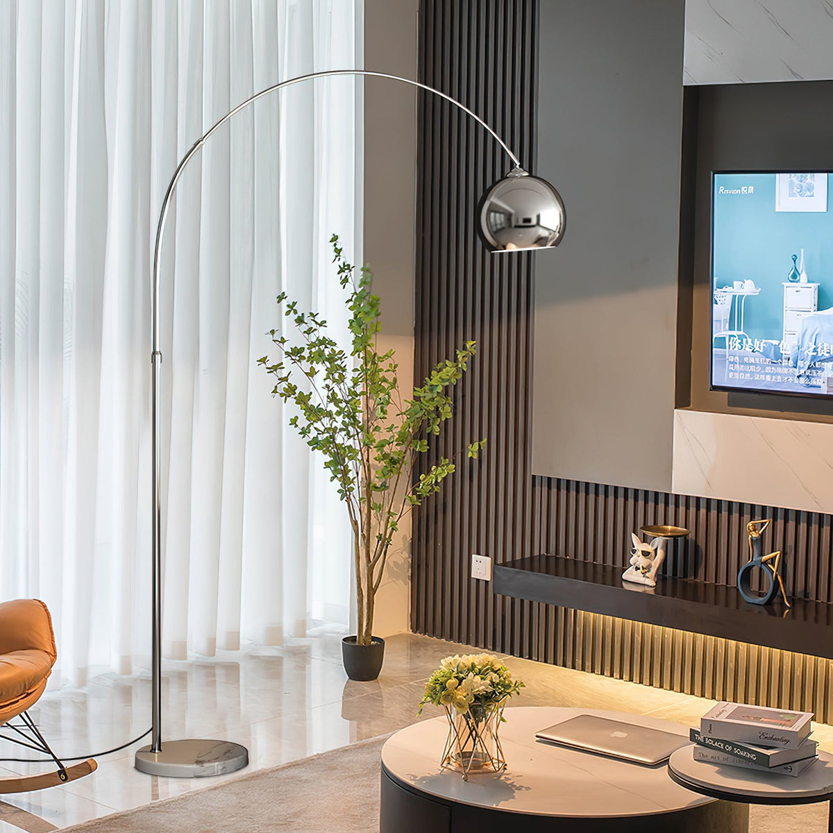 The slim stem of this Clérachic chrome arc lamp rises past a green plant and sheer curtains in a living room with a slatted wall.