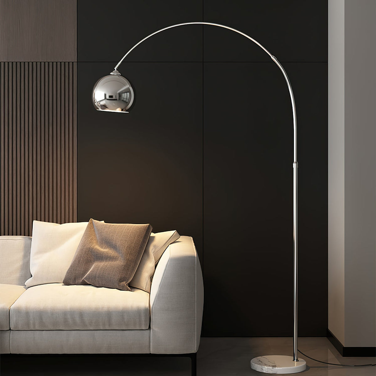 Against a dark wood-slat wall, this Clérachic chrome arc lamp rises behind a cream sofa with a brown cushion.