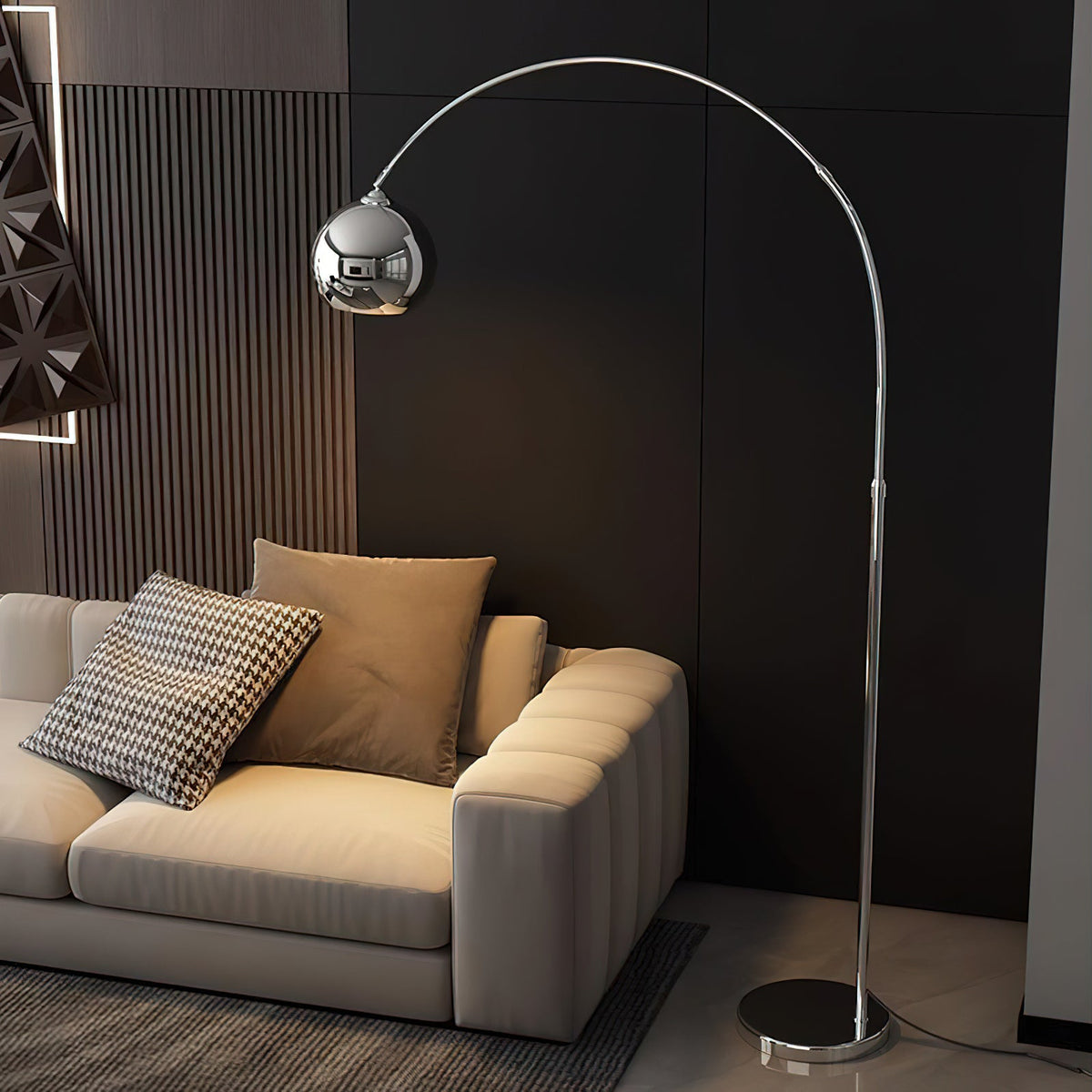 Chrome arc floor lamp from Clérachic beside a cream sofa with a houndstooth cushion, in front of a dark panelled wall.