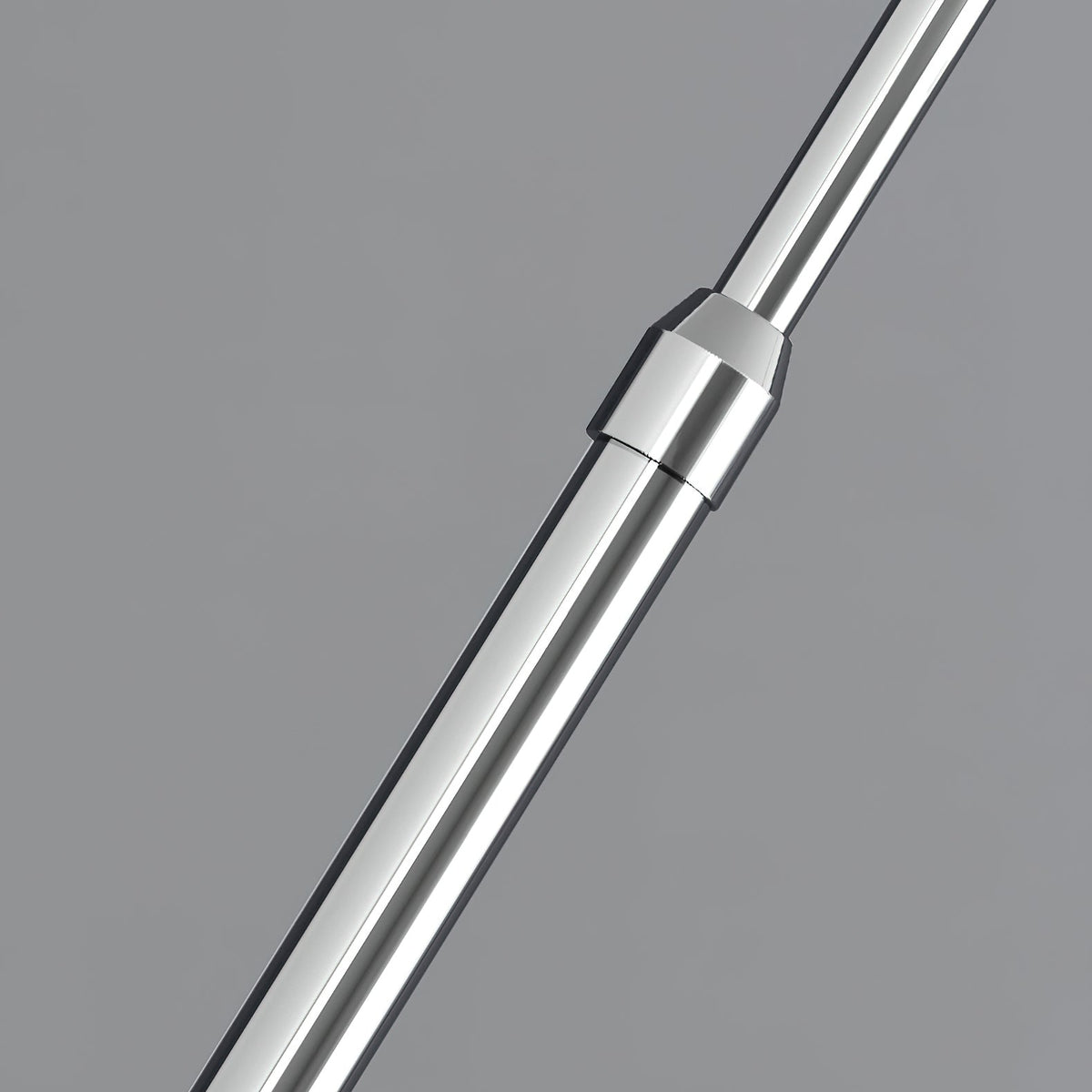 Close view of the chrome telescopic joint in the stem of this Clérachic arc lamp, against a grey background.