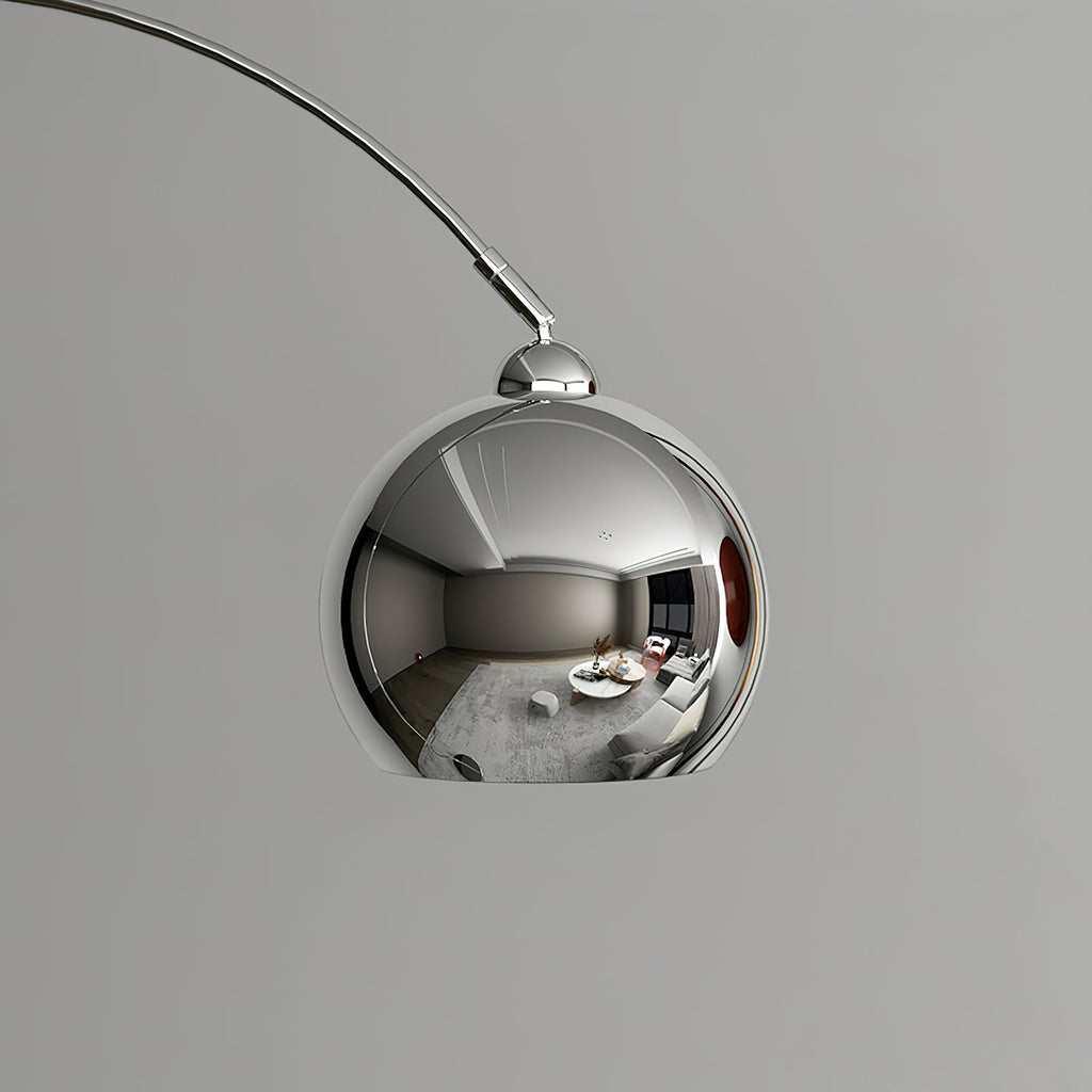 Close view of the mirror-polished chrome ball head on this Clérachic arc lamp, reflecting a room.