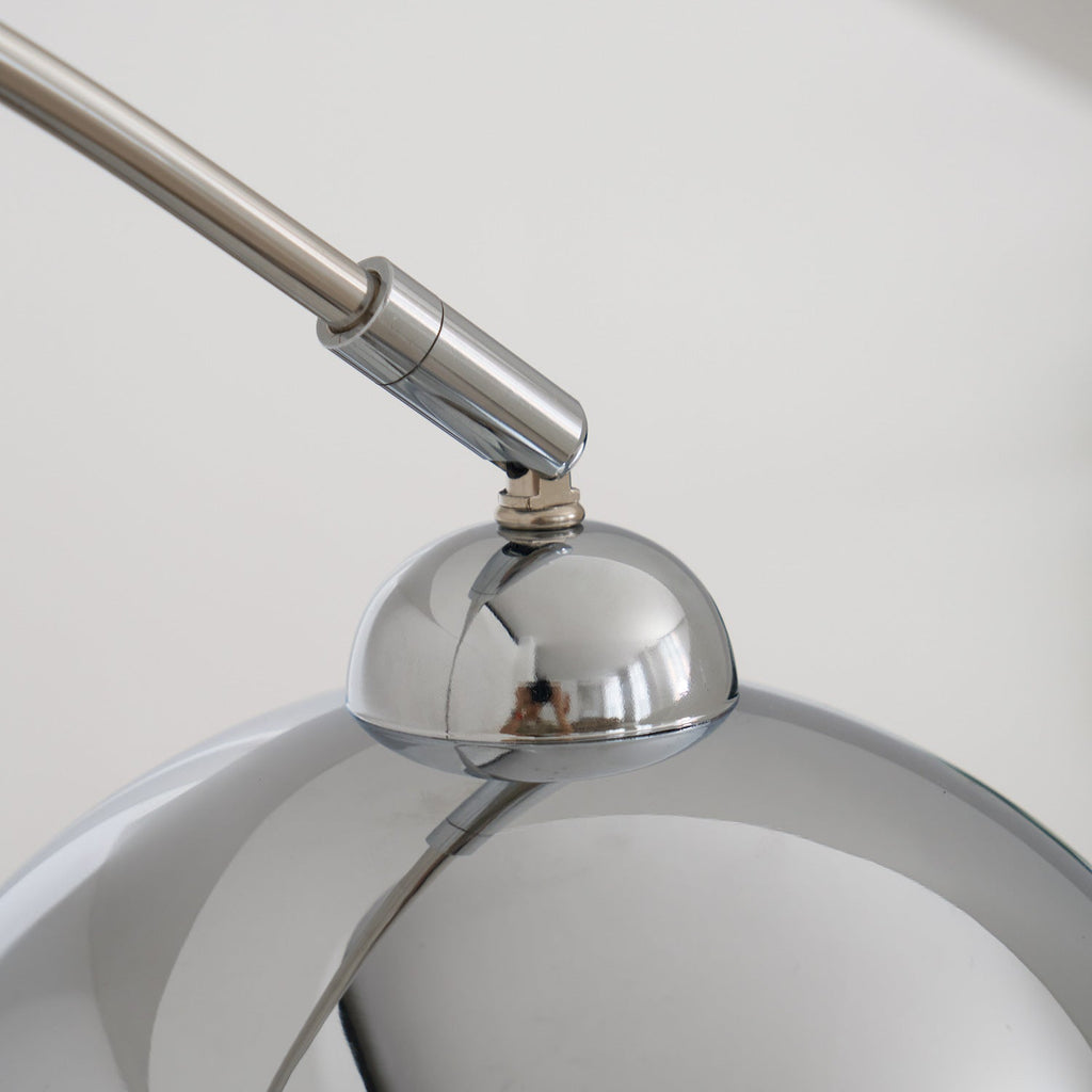 Close view of the tilting joint where the arm of this Clérachic arc lamp meets its polished chrome head.