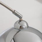 Close view of the tilting joint where the arm of this Clérachic arc lamp meets its polished chrome head.