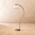 Clérachic arched floor lamp with a bent light-wood stem, black horseshoe base and a white pleated shade on limewash.