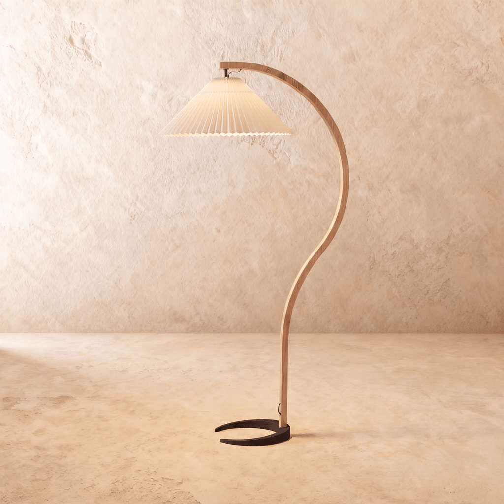 Clérachic arched floor lamp with a warm beige pleated shade, a curved wooden stem and a dark horseshoe base.